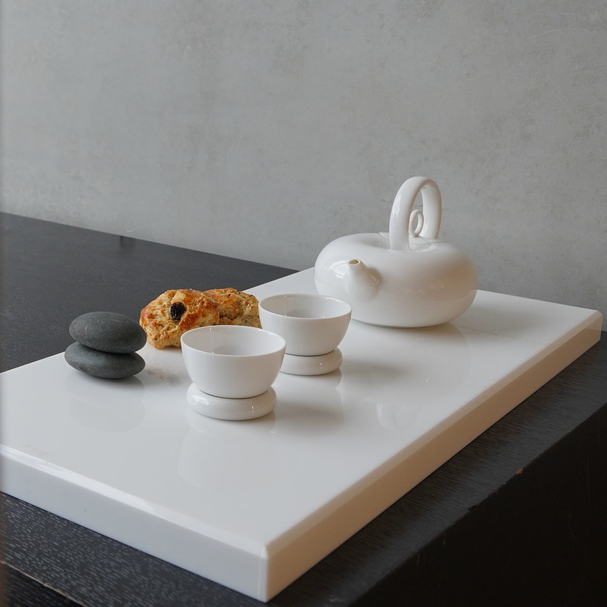圓好夢白瓷茶壺與茶杯置於白色展示台,呈現現代茶席陳列