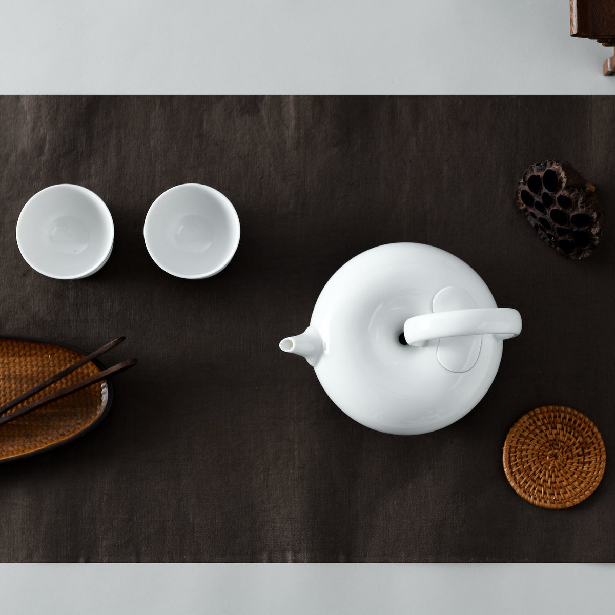 圓好夢白瓷茶具深色茶席俯視圖,茶壺、雙杯與竹製茶席配件整齊排列