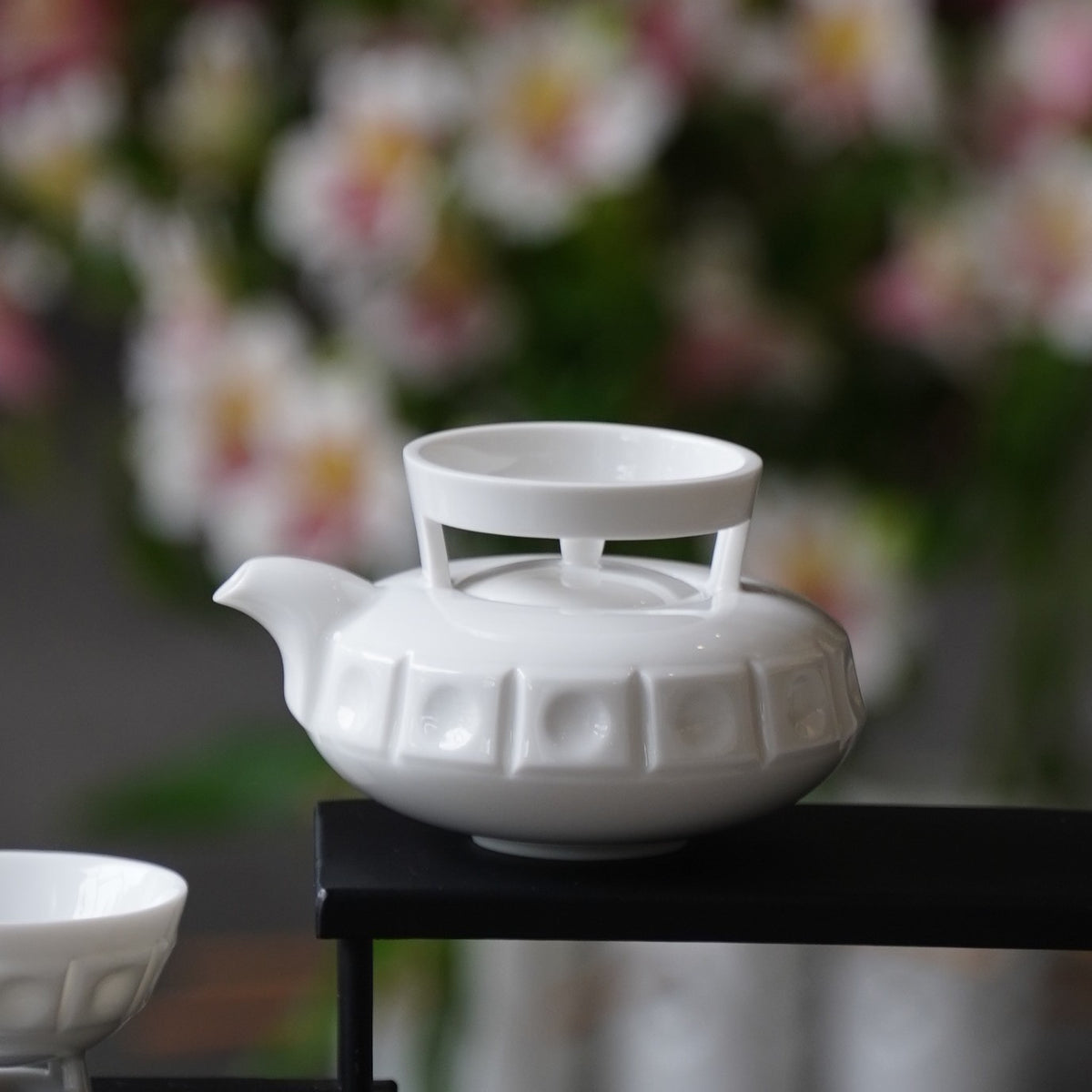 〈璀璨〉茶壺側面,背景是花