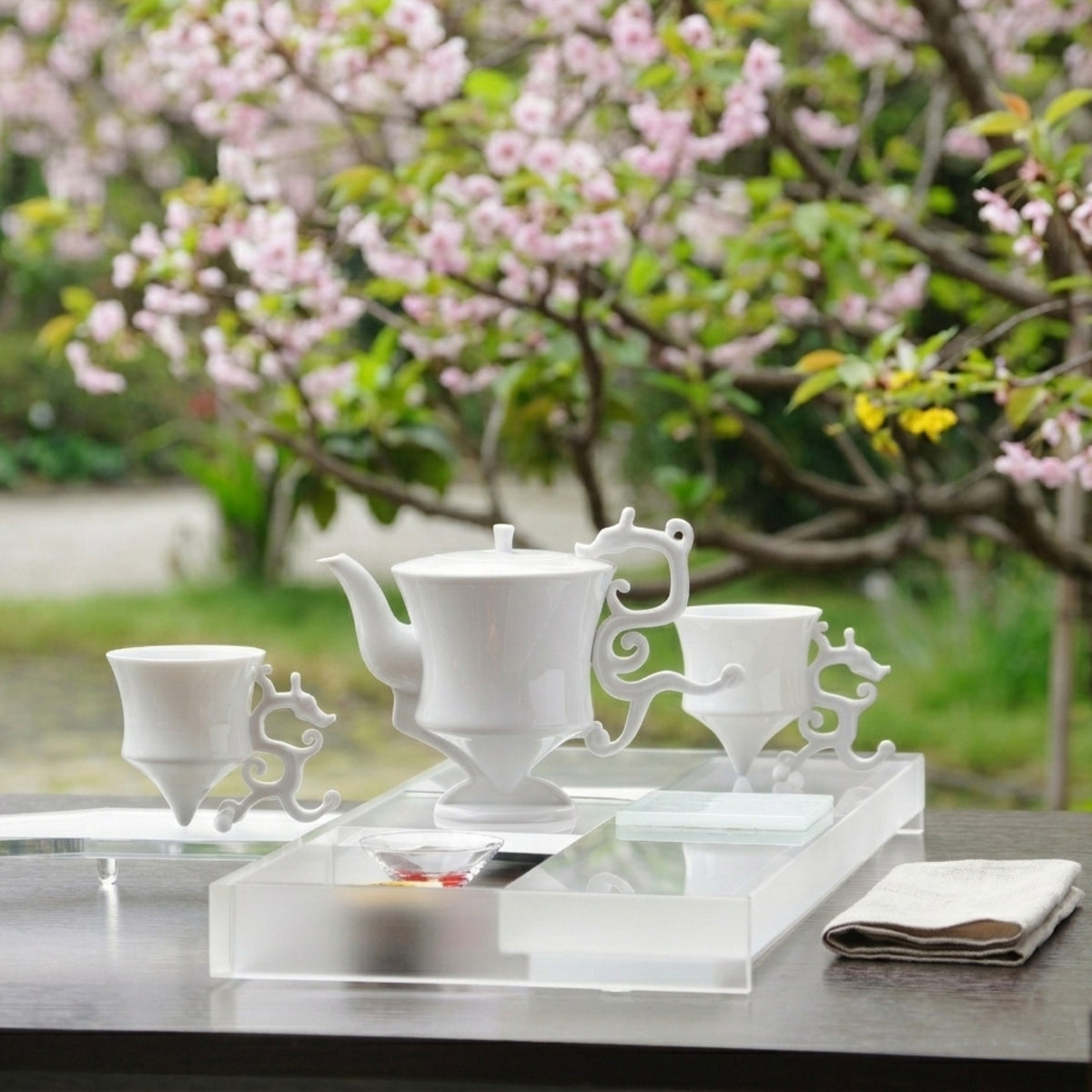 龍尊壺杯組白瓷茶具,戶外櫻花背景,春日品飲場景,展示整組氣韻,八方新氣