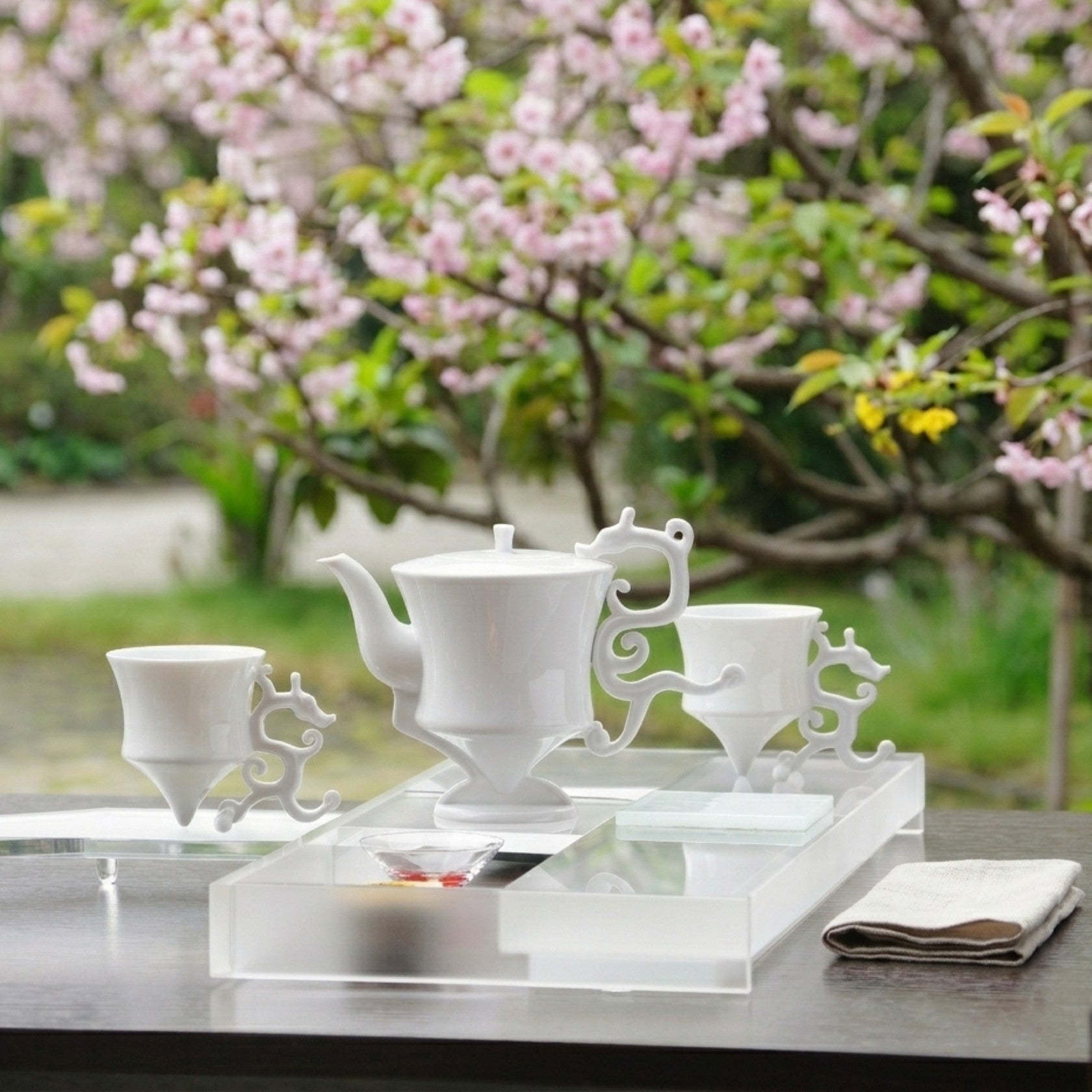 龍尊壺杯組白瓷茶具,戶外櫻花背景,春日品飲場景,展示整組氣韻,八方新氣
