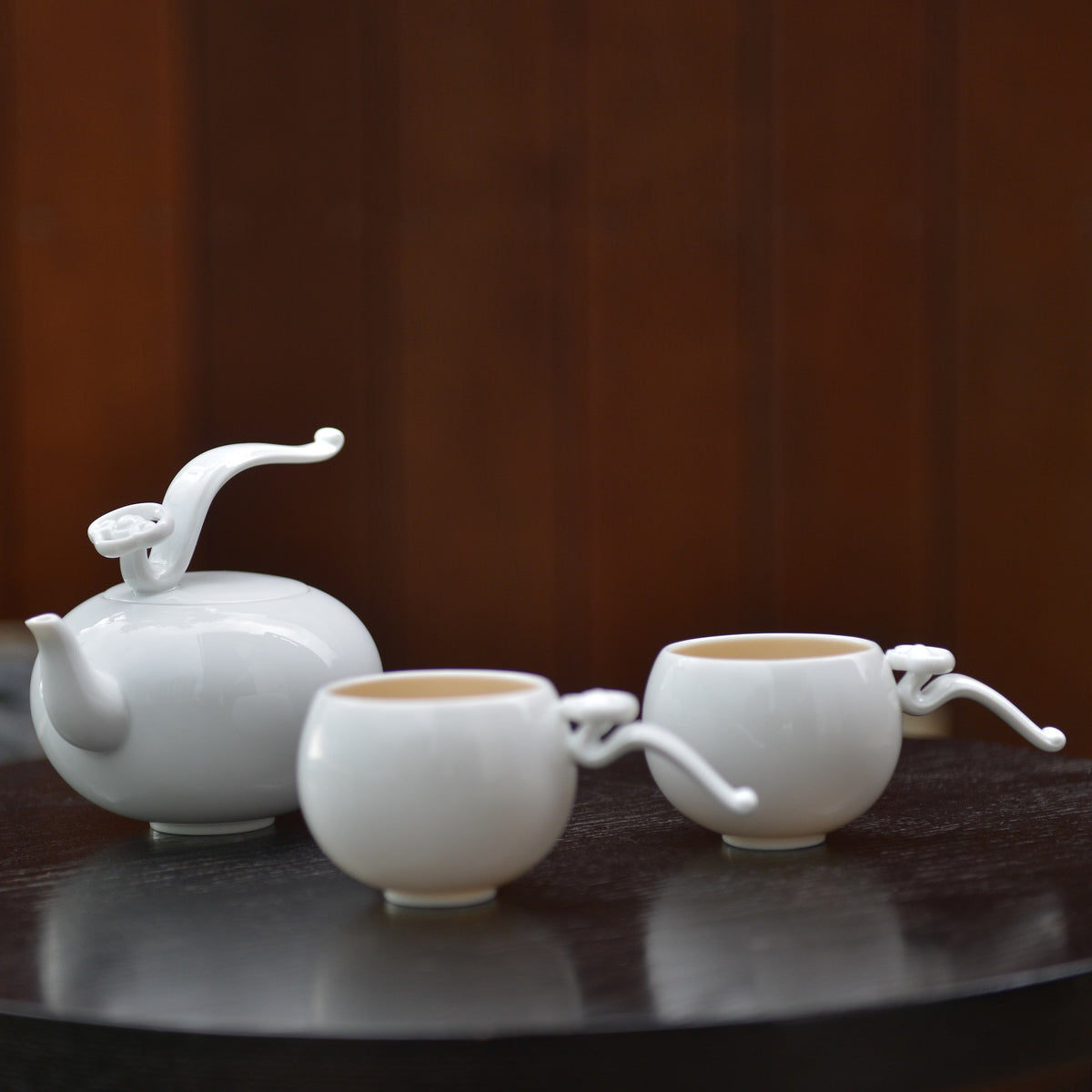 〈如意高飛〉茶壺與兩只茶杯,深色桌面