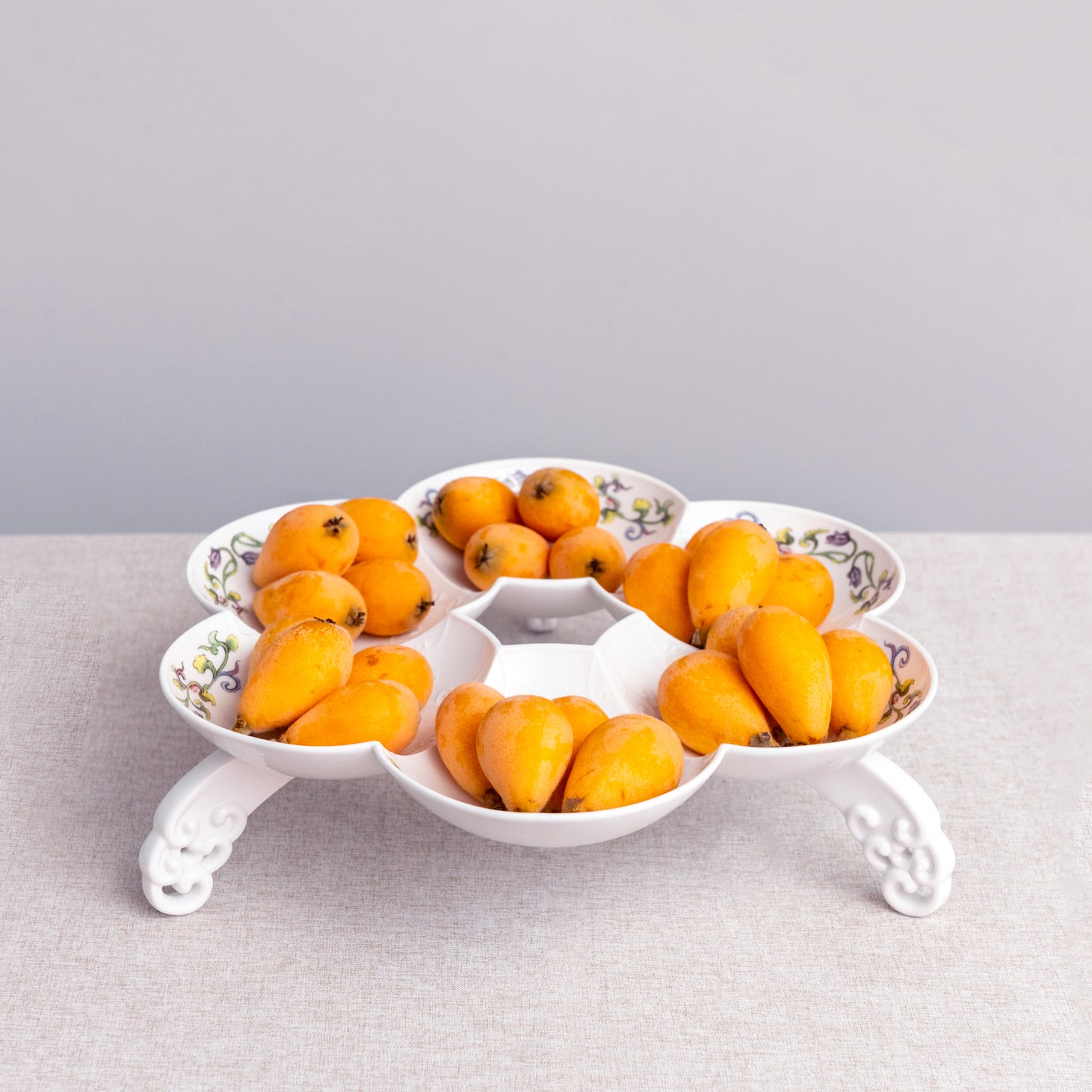 白瓷水果盤置於現代簡約場景中,展現雲紋與浪花細節。