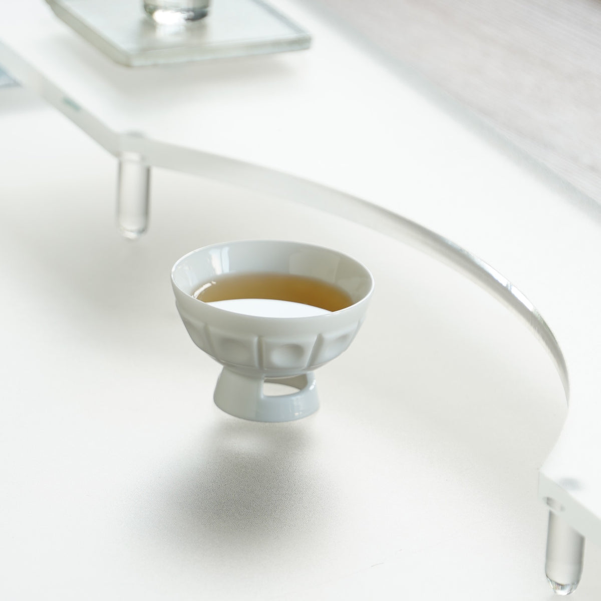 〈璀璨〉茶杯盛茶,置於壓克力檯