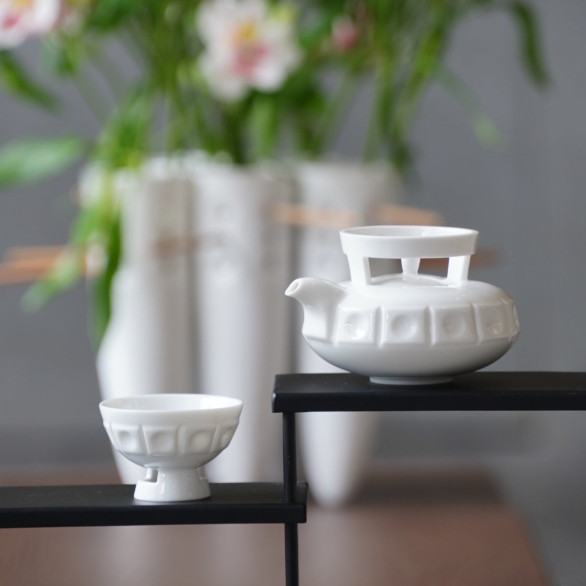 〈璀璨〉茶壺與茶杯，白瓷花器旁