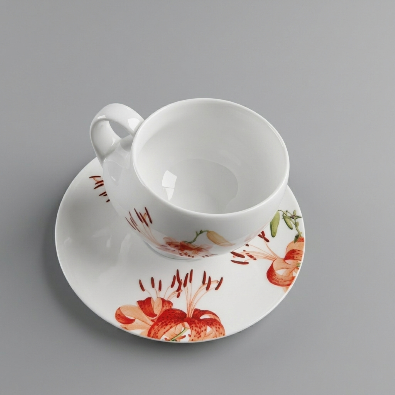 青春 Top view of In Bloom porcelain cup and saucer, showing lily blossom composition integrated with the circular form