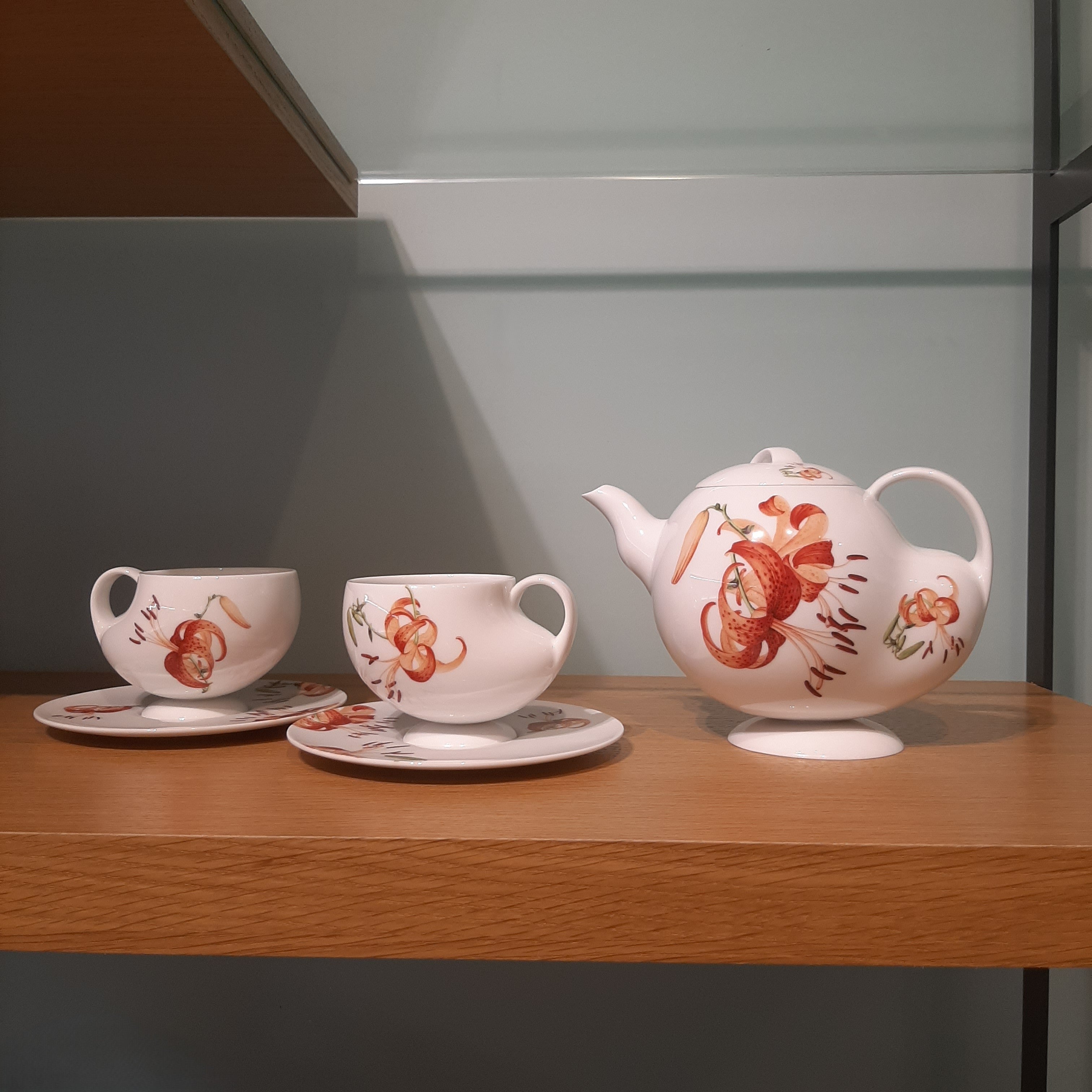 青春 In Bloom porcelain tea set photographed against a decorative interior backdrop, showcasing floral patterns inspired by Giuseppe Castiglione
