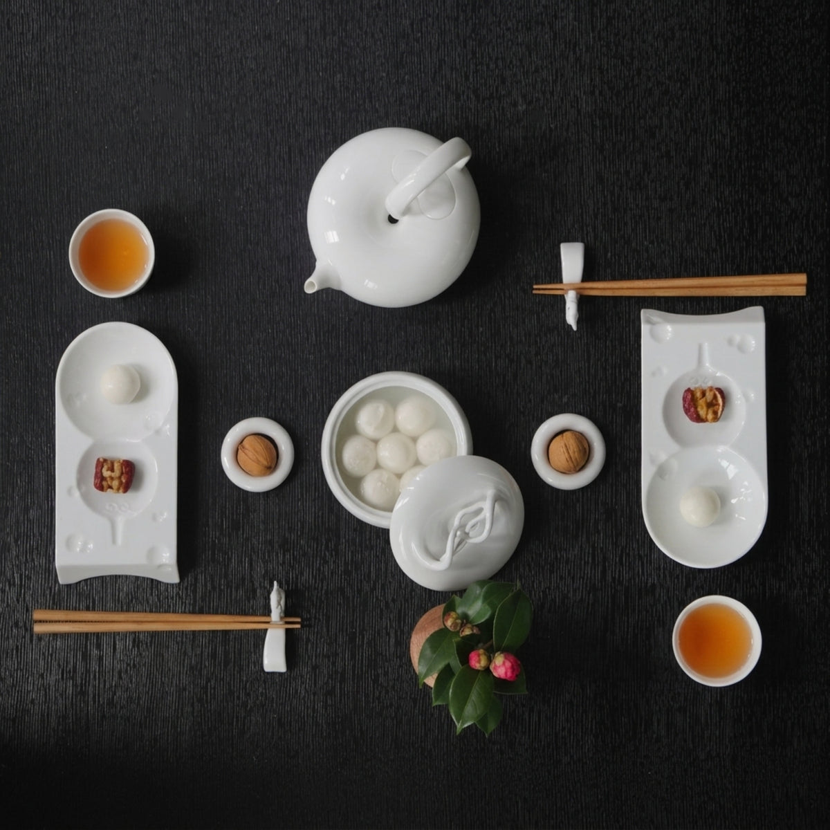 圓好夢白瓷茶具俯視茶席，茶壺、茶杯、茶點與花藝依幾何秩序排列