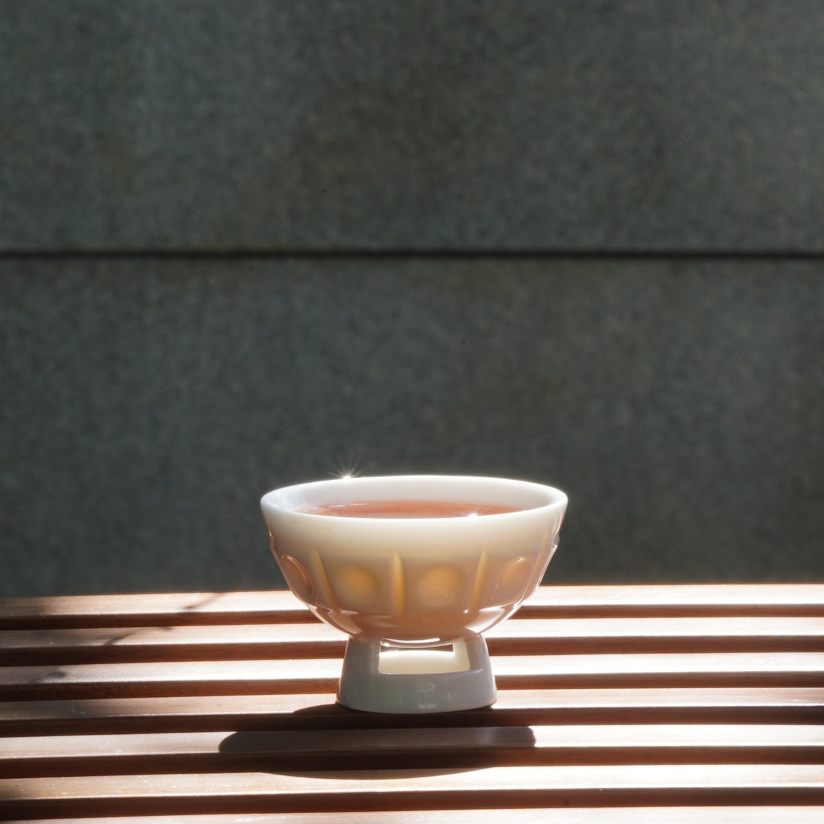 〈璀璨〉茶杯盛茶，木條桌面
