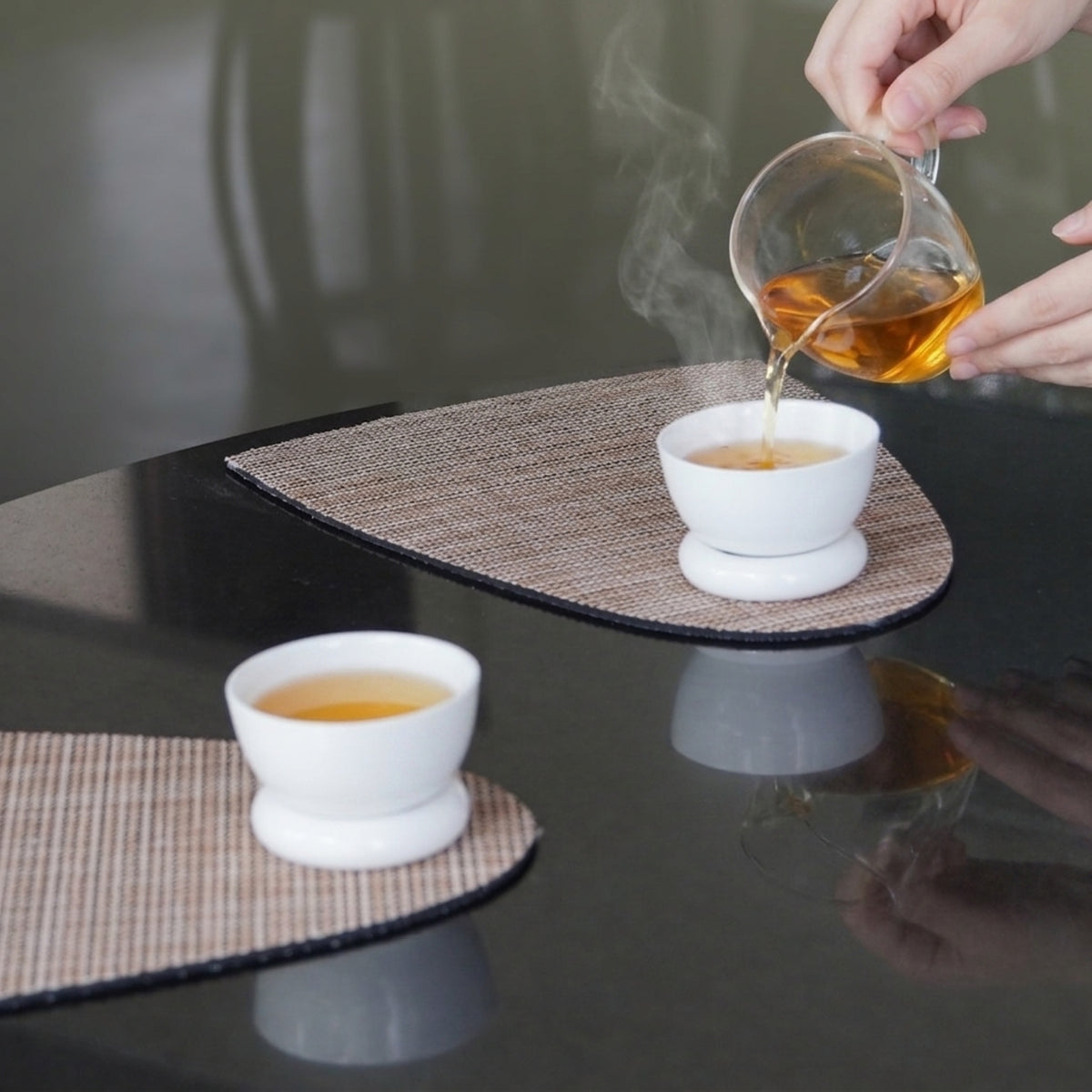 將茶湯倒入〈圓好夢〉茶杯，杯座置於餐墊