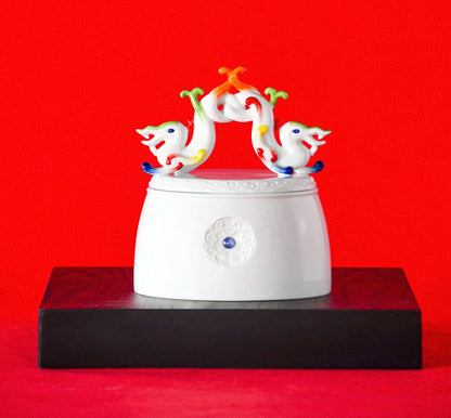 白瓷雙龍環繞瓷盒作品彩繪妝點，象徵喜氣與友誼的雙喜福鎮擺件