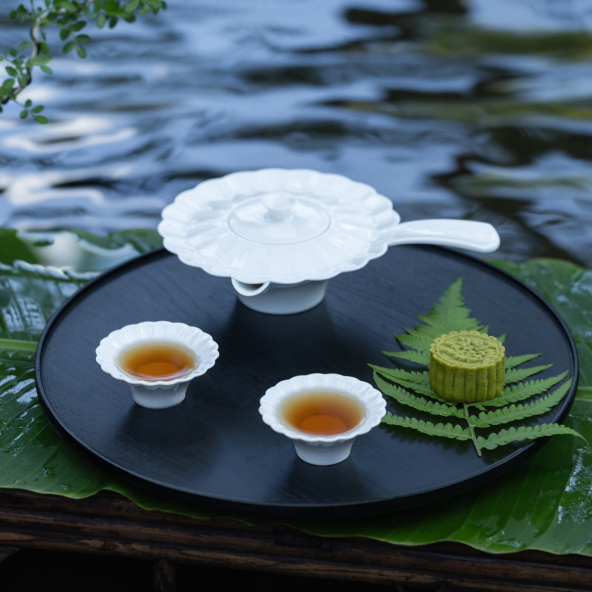 〈山水情深〉白瓷茶壺茶杯，背景是山間瀑布