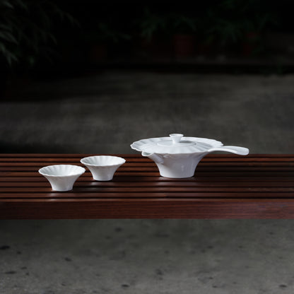 〈山水情深〉茶壺與兩只茶杯並列於木長凳，庭院夜景