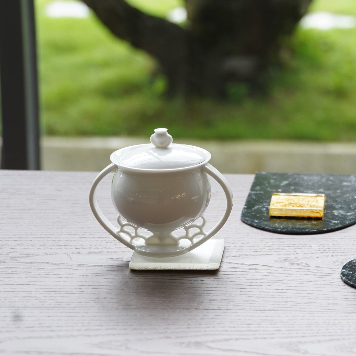 〈滿庭芳〉蓋杯，窗邊木桌上