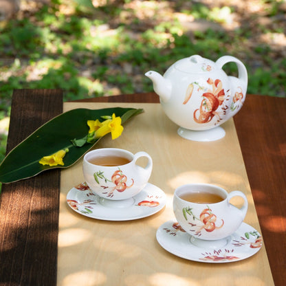 青春 In Bloom 百合白瓷茶具組，白瓷茶壺與茶杯於戶外自然光下展示，展現百合花盛放的生命力