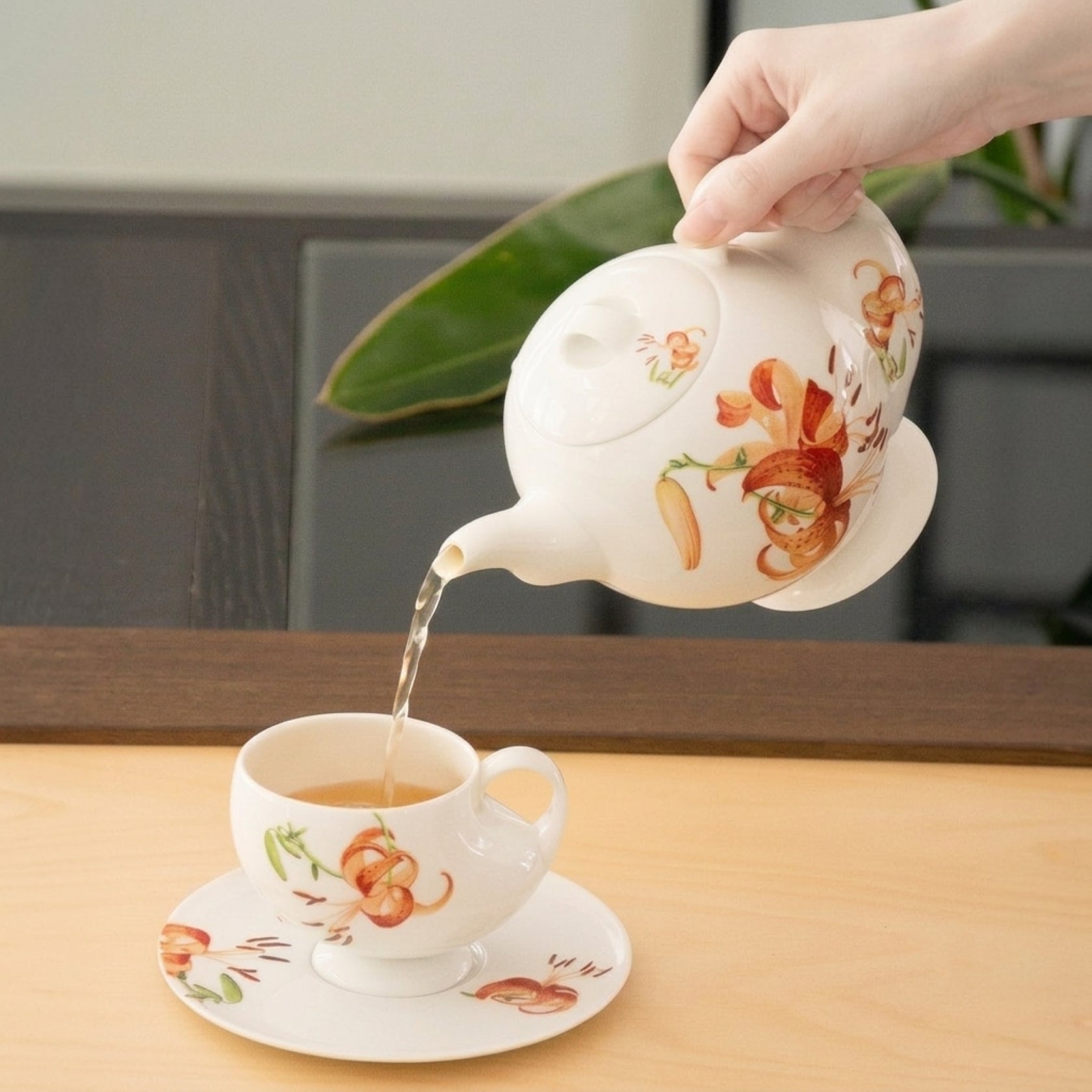 青春 In Bloom 百合白瓷茶壺倒茶畫面，展現故宮清香系列花卉設計